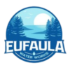 Logo of Eufaula Water Works with a scenic background of a river and trees at sunset, depicted in light blue tones.